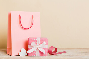 Shopping bag with gift box on colored background perspecrive view. Space for text holiday concept