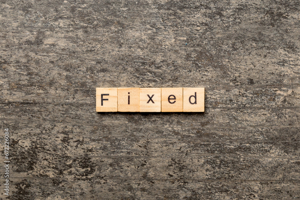 Fototapete fixed word written on wood block. fixed text on table, concept