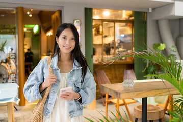 Woman hold with a phone in the cozy design cafe