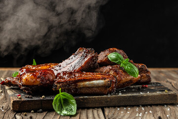 Hot grilled pork ribs with sauce and smoke on a wooden board. Restaurant menu, dieting, cookbook recipe