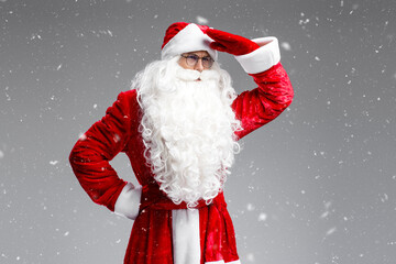 Pensive Santa Claus looking away  isolated on gray background with snow. Winter, Christmas concept