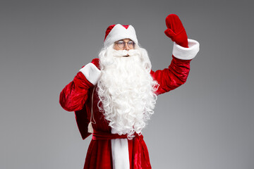 Saint Nicholas holding bag with gifts  waving hand looking away isolated on black background. Marry Christmas, Happy New year concept 