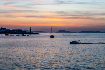 Fototapeta na wymiar Sunset in the Vigo estuary. Photographed from the Bouzas neighborhood. You can see the Museum of the Sea and a sailboat at anchor. Galicia, Spain.