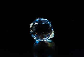 A close-up with a precious stone shining on a black background. A large isolated diamond...