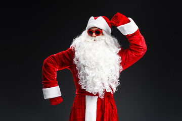 Funny Santa Claus wearing stylish sunglasses dancing celebration winter holidays isolated on black...