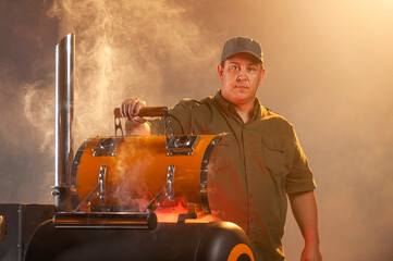 Barbecue master. Middle aged hispanic man for barbecue in front of pit smoker. Roasting, grilling and smoking food. Roasting meat outdoors. Barbecue and grill.