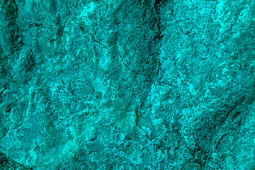 Blue green abstract background. Toned rough rock surface texture. Beautiful teal background.