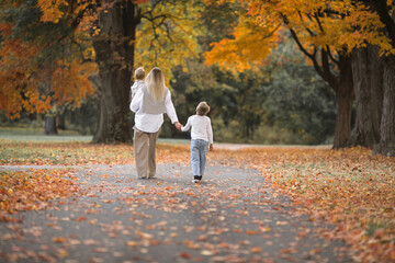 Fototapeta premium Mothers day, love family. Family on autumn walk in nature outdoors. Mother and child with hugging tenderness