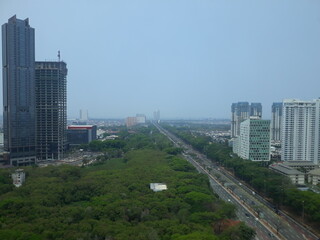 Fototapeta premium High angle view jakarta indonesia city scape with tower building, highway street and green public park