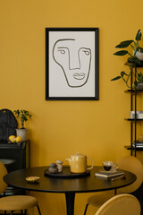 Stylish composition of warm dinning room interior with mock up poster frame, round table, yellow chair, glass vase with dried flowers, lamp, and personal accessories. Home decor. Template.