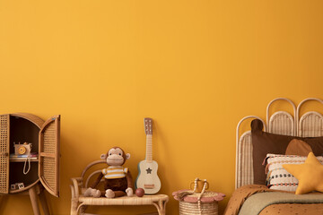 Aesthetic composition of kid room interior with yellow wall, guitar, rattan bed, toys, plush...