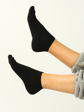 Black Socks With Copy Space On Human Foot Close Up Photo On White Background