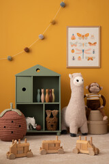 Interior design of warm kids room with mock up poster frame, green shelf, plush lama, yellow wall, monkey, brown bedding, wooden block, garland on wall and personal accessories. Home decor. Template.