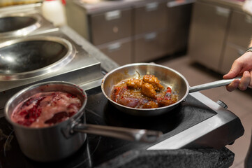 Chef cook hand cooking food in pan at the restaurant kitchen