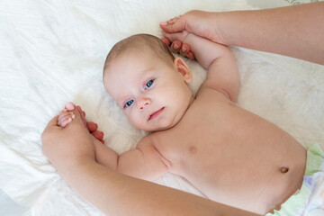 Gymnastics and warm-up with an infant. Baby care concept