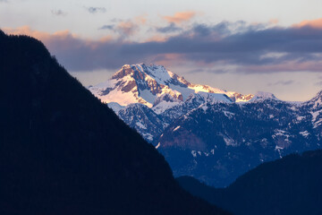 Fototapeta premium Golden sunset light hitting snow capped mountain peaks in Golden Ears Provincial Park. Maple Ridge, British Columbia