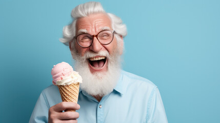 Happy senior man eating ice cream at blue background