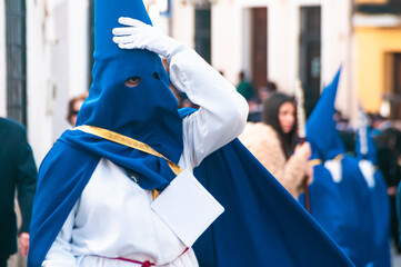 Representative of the local religious brotherhood in blue attire during procession on Holy Week...