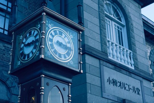 Old clock tower atop a stone structure beside an old, brick building in Sapporo, Hokkaido, Japan