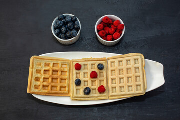 waffles with berries on a dark slate