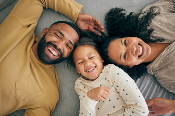 Happy family, above and kid smile or happy with parents together in the morning laughing in a bedroom on a bed. Relax, mom and dad enjoy quality time with kid with happiness, bonding and love - obrazy, fototapety, plakaty