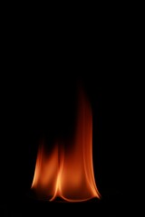 Vertical shot of flames isolated on a black background for textures