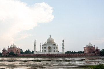 Fototapeta na wymiar The imposing Taj Mahal in Agra, India, with its wonderful architecture on a cloudy day from a view across the river