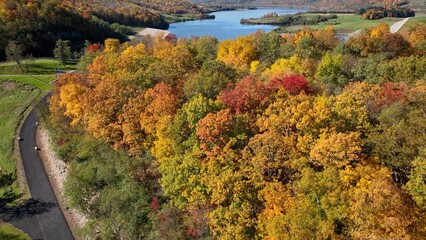 Fototapeta na wymiar Autumn Fall colors in trees in beautiful sunlight showing bright orange, red and yellow colors across the countryside landscape