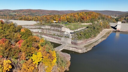 Fototapeta na wymiar Hammond-Lakes Dam and Reservoir in Tioga, Pennsylvania peaceful lake and water in Autumn Fall colors in mountain trees in morning sunlight where boating and fishing is permitted