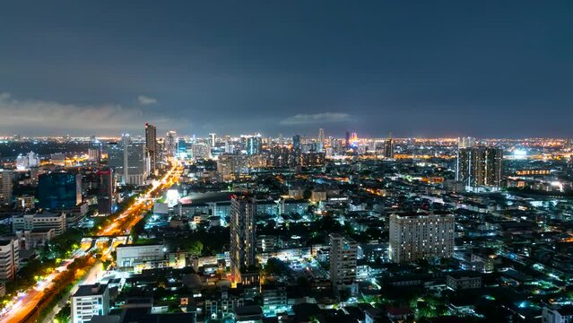 Time lapse of night sky over big city of Bangkok with road traffic high rise buildings.