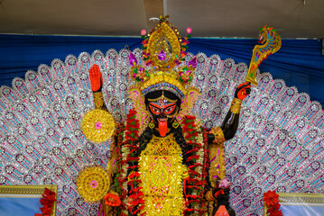 Idol of Goddess Maa Kali at a decorated puja pandal in West Bengal, India. Kali puja is a famous...