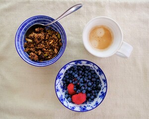 Top view of a delicious breakfast with coffee and granola with fresh berries on the table