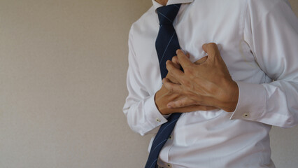 胸の痛み襲われるビジネスマン｜心筋梗塞・動悸などのイメージ