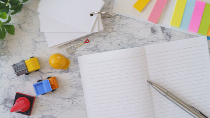 ミニチュアのダンプカーとヘルメットと勉強道具｜建設系の資格取得　イメージ © aomas