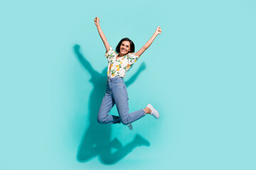 Obraz premium Full length photo of carefree cheerful girl wear trendy outfit raise fist yes hooray good mood isolated on bright cyan color background