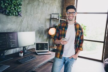 Photo of smart successful it company executive guy hold smart phone coworking loft interior...
