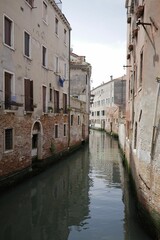 Tranquil urban scene with a river with tall buildings in the background in Venice