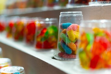 Close-up of an array of gummy worms in cups on a carnival stand