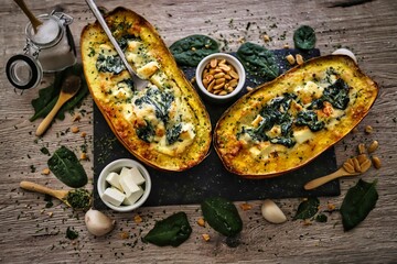 Closeup of squash filled with vegetables and greens on a wooden table