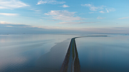 Aerial view of the man-made road through the North Sea to another part of the Northern Netherlands. Unique transport construction - obrazy, fototapety, plakaty