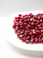 Close-up of a plate with a fresh pomegranates isolated on a white background