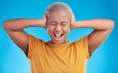 Headache, hands on ears and black woman shout in studio isolated on a blue background. Stress,...