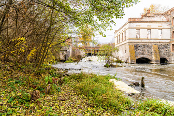 Dam, old water mill, seething rushing water, bridge.