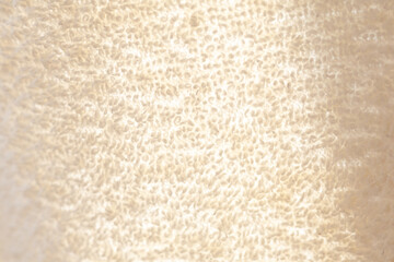 Beige shiny cotton towel or carpet.fluffy texture background. Close up, macro photo.