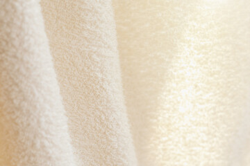 Beige shiny cotton towel or carpet.fluffy texture background. Close up, macro photo.