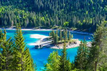Small island in the middle of Cauma Lake (Caumasee) with crystal blue water in beautiful mountain landscape scenery at Flims, Graubuenden - Switzerland - 672314630