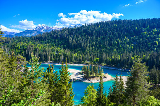 Small island in the middle of Cauma Lake (Caumasee) with crystal blue water in beautiful mountain landscape scenery at Flims, Graubuenden - Switzerland