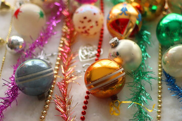 Colorful vintage Christmas ornaments and white faux fur blanket. Cute and kitschy Christmas decorations. Selective focus.