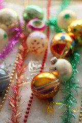 Colorful vintage Christmas ornaments and white faux fur blanket. Cute and kitschy Christmas decorations. Selective focus.