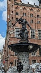 Bronze statue of standing proudly in the middle of a fountain in Gdansk